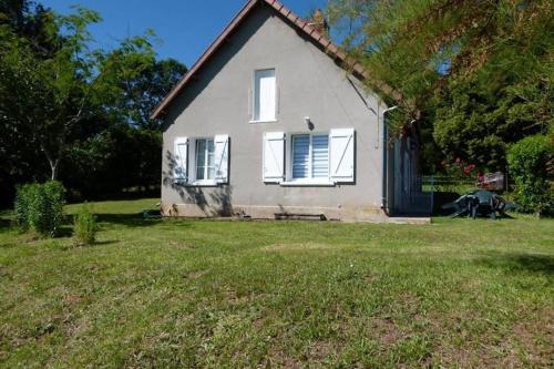 una casa blanca con un banco en un patio en Gîte en Brenne Les Chênes, en Mérigny