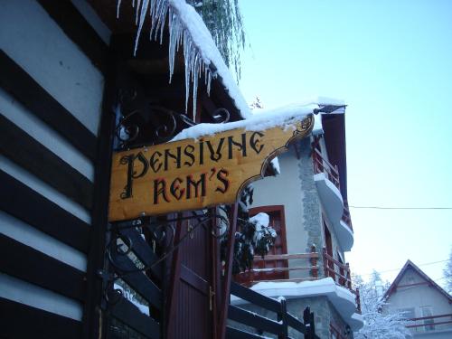 a sign on the side of a building with snow on it at Rem's Pension in Râşnov