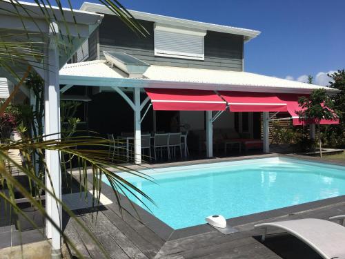 a swimming pool in front of a house at Villa Shenandoah in Sainte-Anne