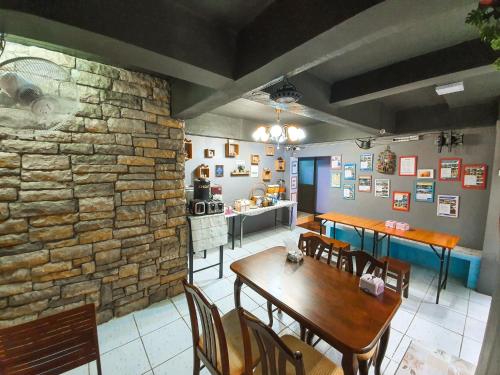 a dining room with a table and a stone wall at Bangkok Canale Home at Khaosarn in Bangkok