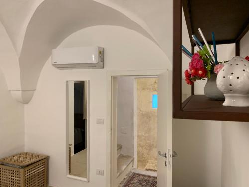a hallway with a mirror and a vase with flowers at VIA DANTE LUXURY in Matino
