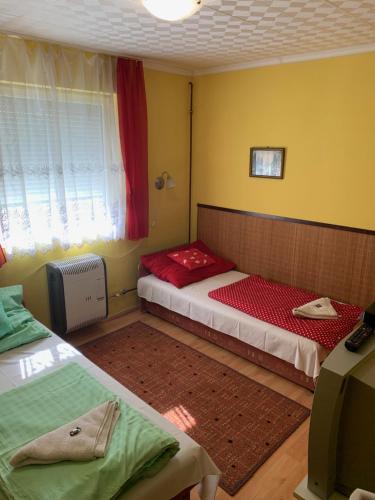 sypialnia z 2 łóżkami i oknem w obiekcie Csipke Vendégház w Mezőkövesd