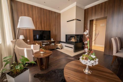 a living room with a television and a fireplace at Villa Meribel in Tatranská Lomnica