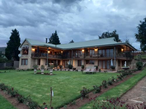 ein großes Haus mit Rasen davor in der Unterkunft Mt Horeb Manor in Clarens