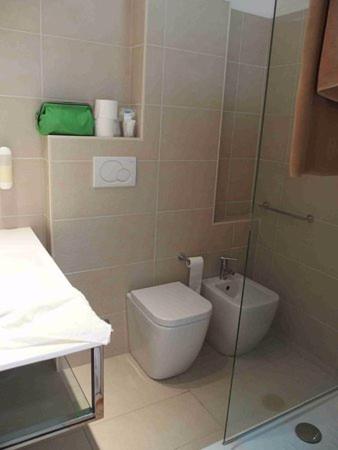 a bathroom with a toilet and a glass shower at Hotel Chic in Cattolica