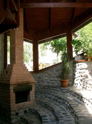 a patio with a brick fireplace in a house at Rem's Pension in Râşnov