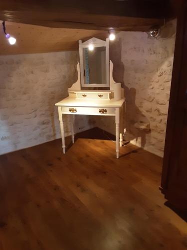 - un bureau blanc avec un miroir au-dessus dans l'établissement La Galerne, à Montpellier-de-Médillan