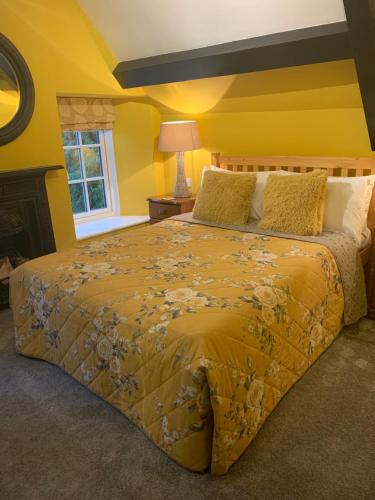 a bedroom with a large bed with yellow walls at The Bell at Old Sodbury in Chipping Sodbury
