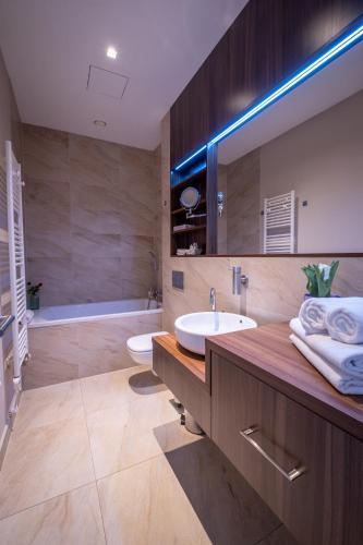 a bathroom with a sink and a mirror and a tub at Villa Meribel in Tatranská Lomnica