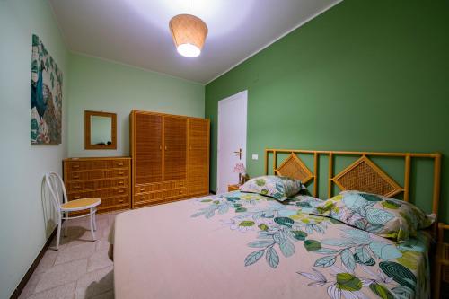 1 dormitorio con 1 cama grande y paredes verdes en Residence l'Ogliastro, en Petrizzi