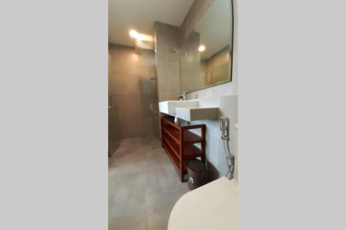 ein Bad mit einem Waschbecken und einem Spiegel in der Unterkunft Casa Raudhah @ Timurbay Seafront Residence in Kampung Sungai Karang