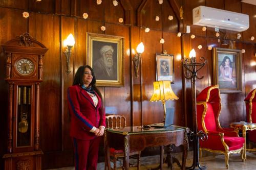 a woman standing in a room with a clock at San Giovanni Stanly Hotel in Alexandria