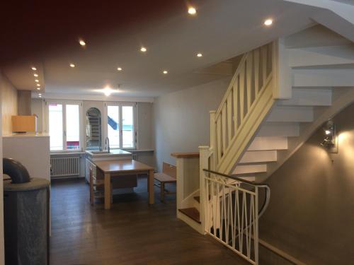 un salon avec un escalier et une table dans l'établissement Maison cœur historique Morlaix, à Morlaix