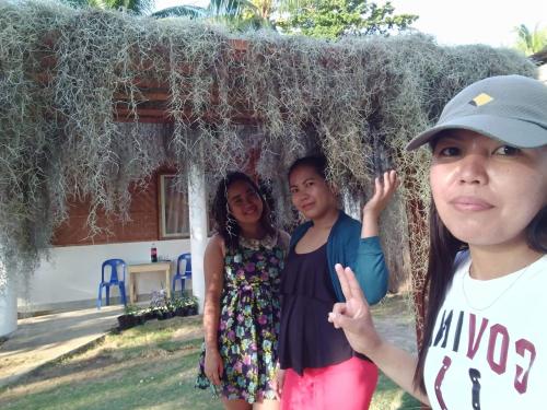 three girls standing in front of a house at SHUKRAN Apartelle in Siquijor
