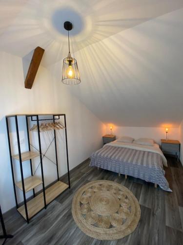une chambre avec un lit et un lustre dans l'établissement Gîte Magnolia Châtenois ALSACE, à Châtenois