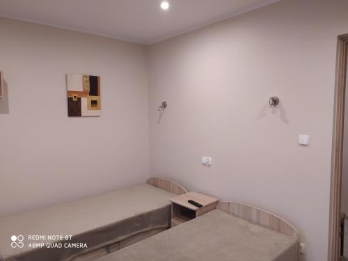 a hospital room with two beds and a table at Dolistówka Apartamenty, pole namiotowe, balia z jacuzzi, ogród warzywny dla gości, plac zabaw dla dzieci in Goniadz