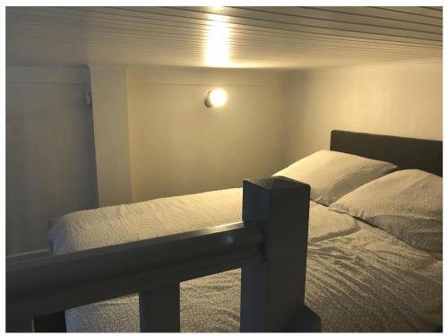 a bedroom with a bed and a light on the wall at Nature & Scandinave in Reims