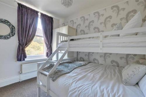 een wit stapelbed in een slaapkamer met een raam bij Pannett View - in the heart of Whitby in Whitby