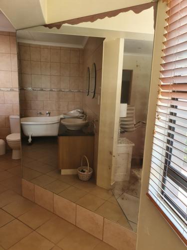 uma casa de banho com uma banheira, um lavatório e um WC. em Gull's Stilbaai em Stilbaai