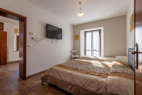 a bedroom with a bed and a tv on the wall at Locanda Zita in Sestola