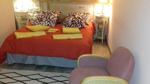 Le vitrail CHAMBRE Équipée sans service repas في Yvetot Bocage: غرفة نوم بسرير احمر مع كرسيين