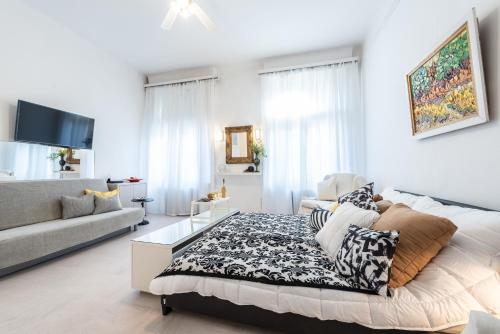 ein weißes Wohnzimmer mit einem Bett und einem Sofa in der Unterkunft Vintage Elegance MostCentralApt !Váci street! in Budapest