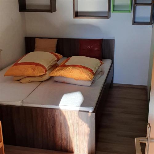 Bett in einem Zimmer mit zwei Kissen darauf in der Unterkunft Terme Banovci - Hiška 74 in Banovci
