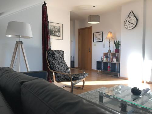 a living room with a couch and a chair and a table at APARTAMENTO MANUEL MARIA in Allariz