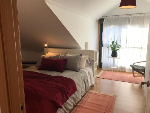 a bedroom with a large bed with red pillows at APARTAMENTO MANUEL MARIA in Allariz