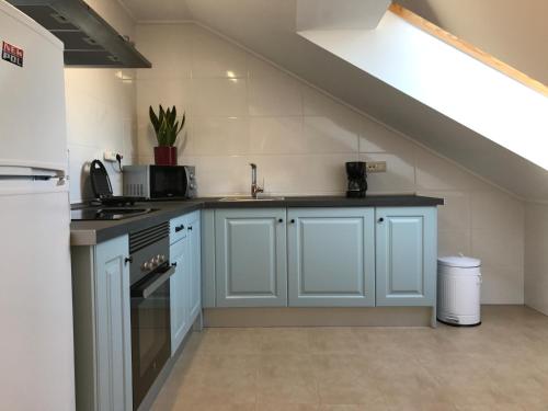 a kitchen with blue cabinets and a staircase at APARTAMENTO MANUEL MARIA in Allariz