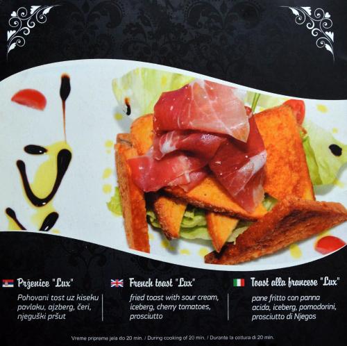 a plate with a sandwich with meat on it at Hotel Ženeva in Kragujevac