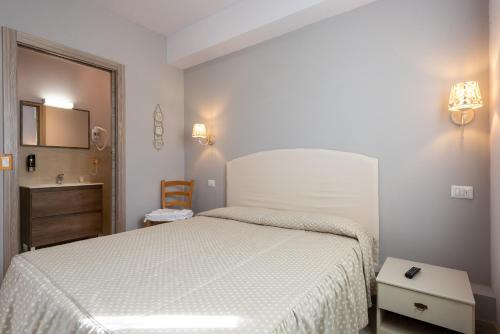 a bedroom with a white bed and a sink at Locanda San Giorgio in Sestola