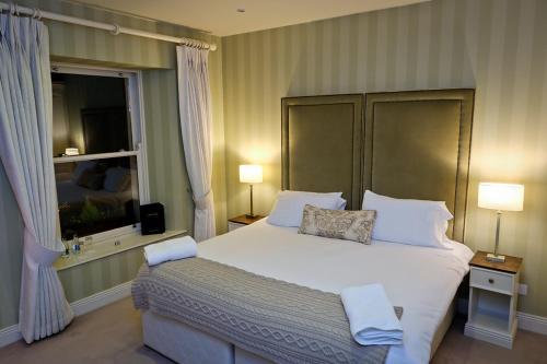 a bedroom with a large white bed and a window at Horse & Hound in Delgany
