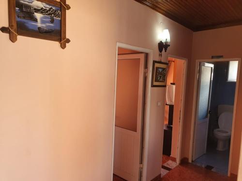 a hallway with a bathroom with a toilet and a mirror at Apartment Donend in Berat
