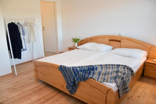 Schlafzimmer mit einem Bett mit einem Kopfteil aus Holz in der Unterkunft Ferienwohnung am Sattelhof in Türnitz