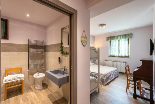 a bathroom with a sink and a bedroom with a bed at Locanda San Giorgio in Sestola