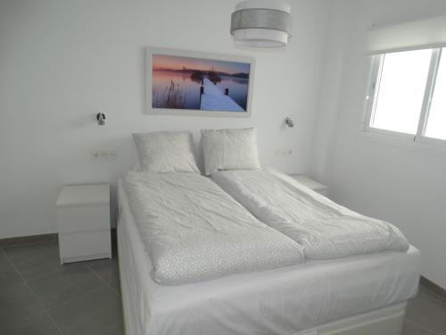 a white bedroom with a bed with white sheets at Málaga Apartamentos - Jinetes, 23 in Málaga