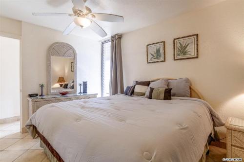 a bedroom with a large bed with a ceiling fan at Lahaina Wonderful Condos - Paki Maui in Lahaina
