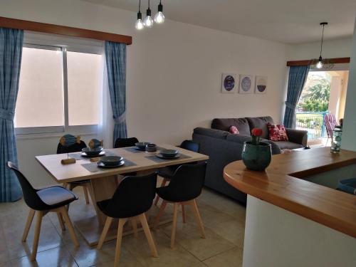 a kitchen and living room with a table and chairs at Paradise Gardens II Anastasia Apartment in Paphos