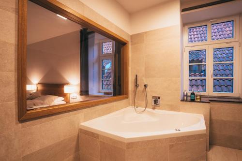 a bathroom with a sink and a mirror and a bed at Latron 98 in Český Krumlov