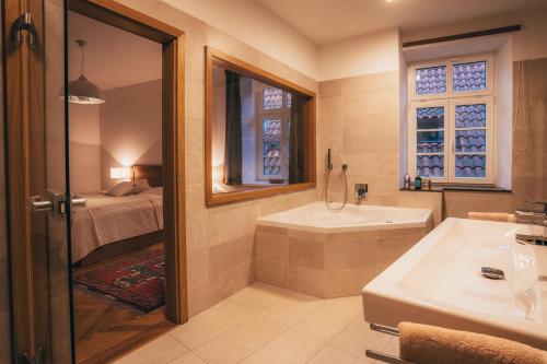a bathroom with a tub and a sink and a bed at Latron 98 in Český Krumlov