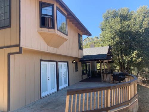 a house with a wooden fence and a porch at Mountain Trail Lodge and Vacation Rentals in Oakhurst