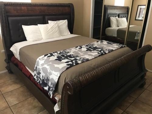 a bed with a black and white comforter and a mirror at Mountain Trail Lodge and Vacation Rentals in Oakhurst