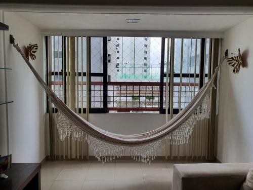 uma rede de descanso num quarto com uma grande janela em Hospedagem Domiciliar - Ótima localização em Piedade no Recife