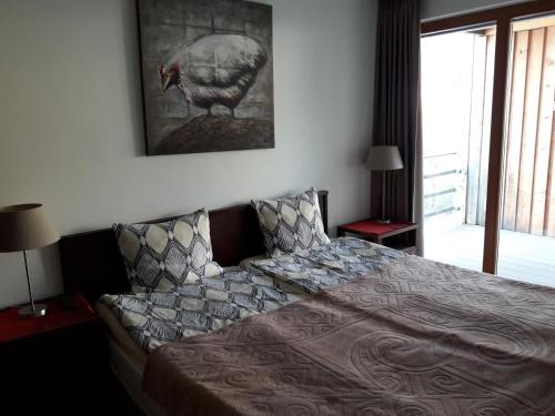 ein Schlafzimmer mit einem Bett und einem Bild eines Truthahns an der Wand in der Unterkunft Holiday apartment #103 on Walensee in Unterterzen