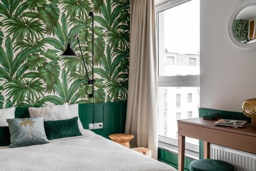 a bedroom with a bed with a green and white wallpaper at Apartament Ap175 in Gdańsk
