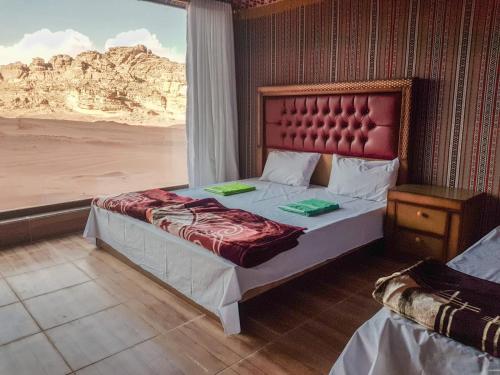 a bedroom with a bed with a view of the desert at WADI RUM STAR WARS CAMP in Wadi Rum