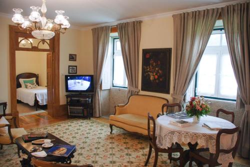 a living room with a couch a table and a television at Casa Mindela Farmhouse in Vila do Conde