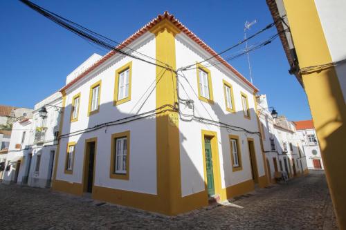 a yellow and white building on a street at Casa dos Castelos in Évora