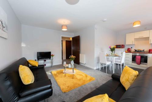 a living room with a black leather couch and yellow pillows at PREMIER - Wishaw En-Suite Apartment in Wishaw